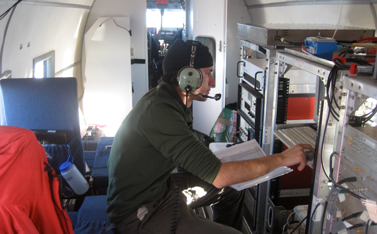 A young scientists conducts analysis in an airplane. 