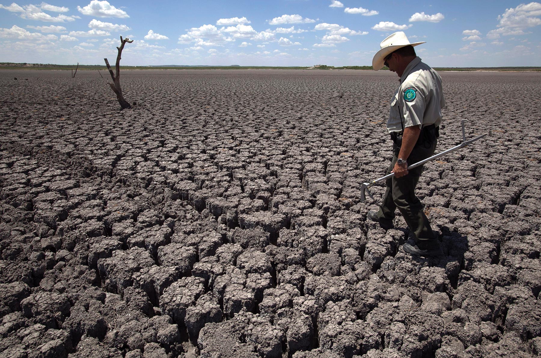 officer walking across cracked lakebed