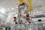 Engineers and technicians use a crane to lift the main body of NASA's Europa Clipper spacecraft in the High Bay 1 clean room of the Spacecraft Assembly Facility at the agency's Jet Propulsion Laboratory.