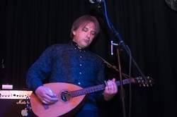 Jeremy on stage playing slide bouzouki.