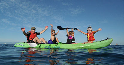 kids and an adult in a kayak