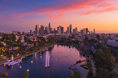 Ett flygfoto över Los Angeles skyskrapor med en park och en sjö i förgrunden.