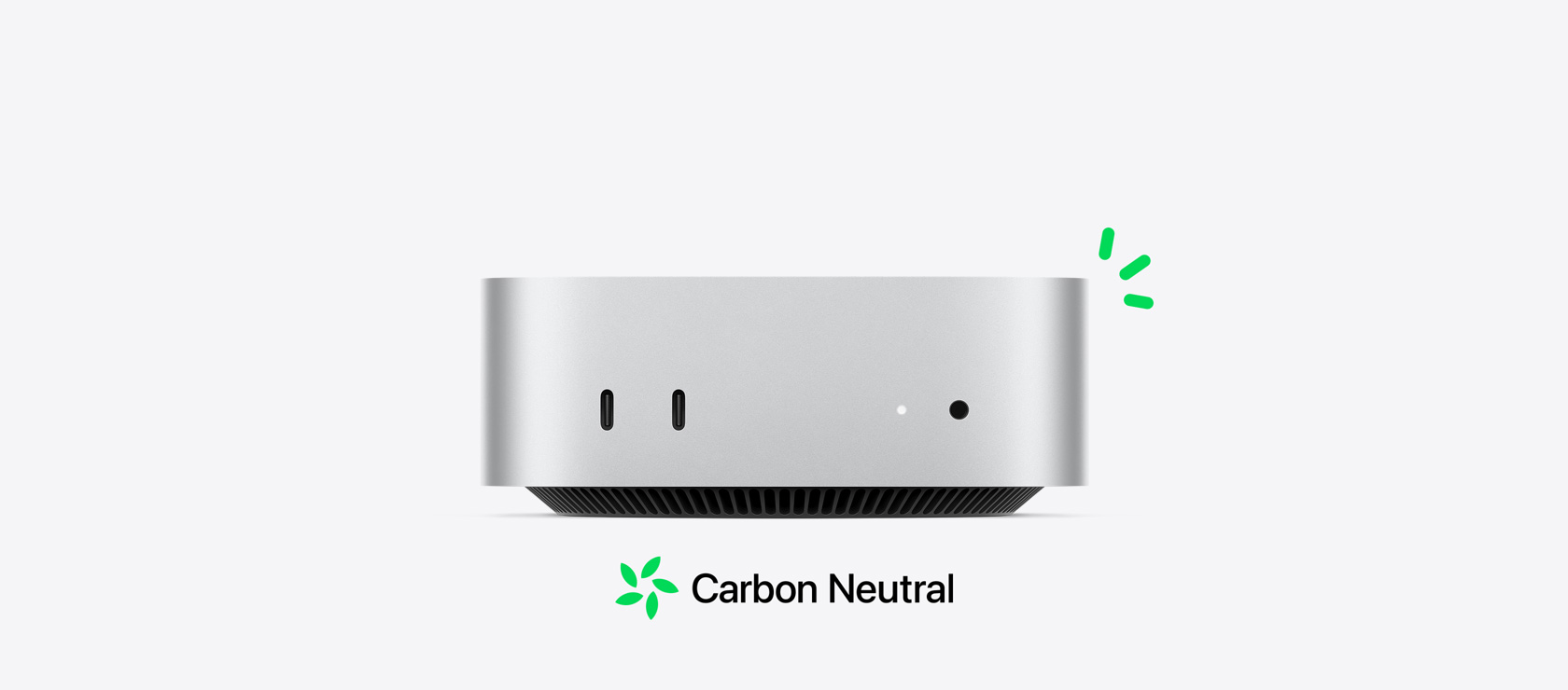 Vue de face d’un Mac mini argent montrant les ports avant, avec de petites illustrations vertes représentant la neutralité carbone. 