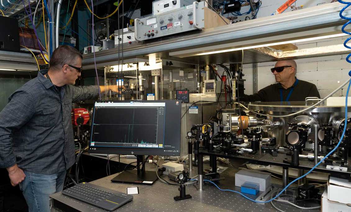 two men standing with accelerator equipment