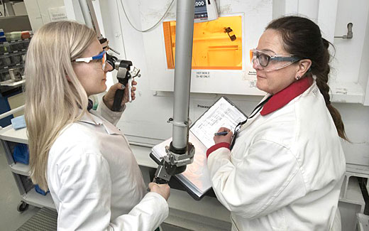 photo of radiochemists in front of manipulator arm system