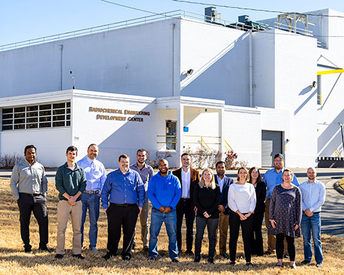 The promethium research team, standing in front of ORNL's Radiochemical Engineering Development