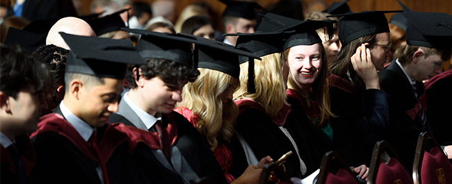 Several students of mixed gender wearing their graduation caps and gowns