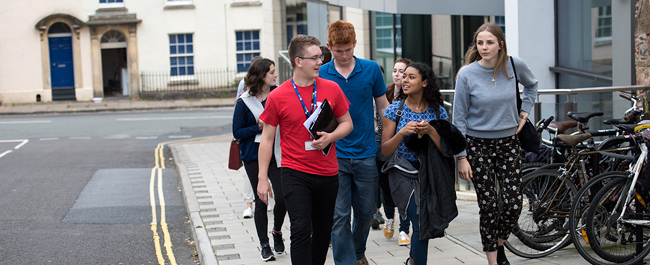 A student ambassador leading a group of prospective students on a tour around campus.