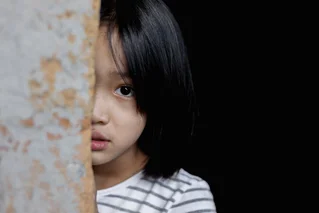 little girl looking scared in doorway