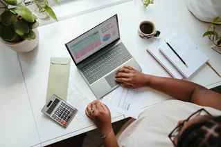 person using computer and calculator