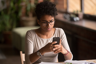 Woman looking concerned at cell phone. 