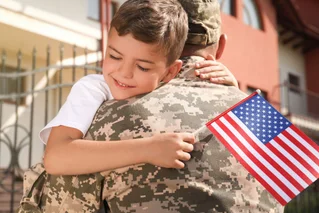 Child hugging soldier with american flag