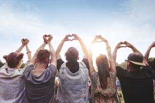 Crowd with hands forming hearts