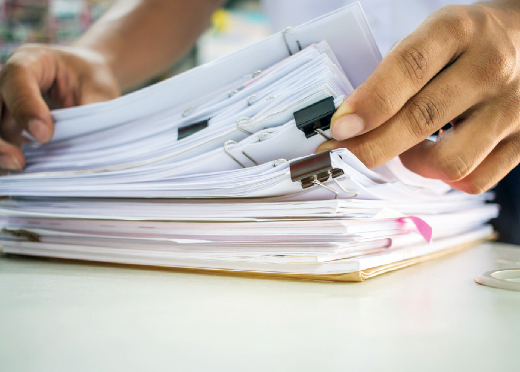 Person looking through stack of documents