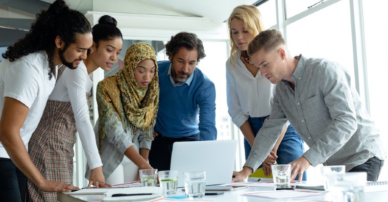 group of people looking at a project on a laptop