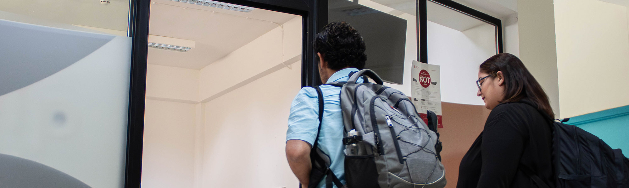 A person at a desk next to the doorway of the Helphub