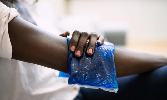 A person holds an ice pack on their arm