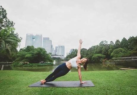 Person doing side plank on yoga mat