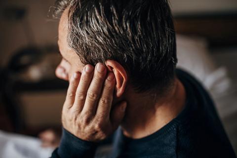 Man holding his hand against his ear