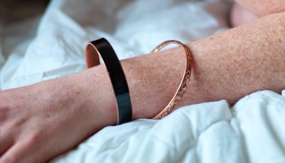 An arm with two copper bracelets on