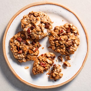 Cowboy cookies on a plate made with coconut flakes chopped chocolate and pecans.