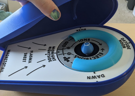 A hand opens the 3D Printed Magnetosphere Model, revealing the internal structures