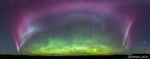 STEVE arcs across the sky of a panorama like a purple rainbow, with green aurora beneath on the horizon.