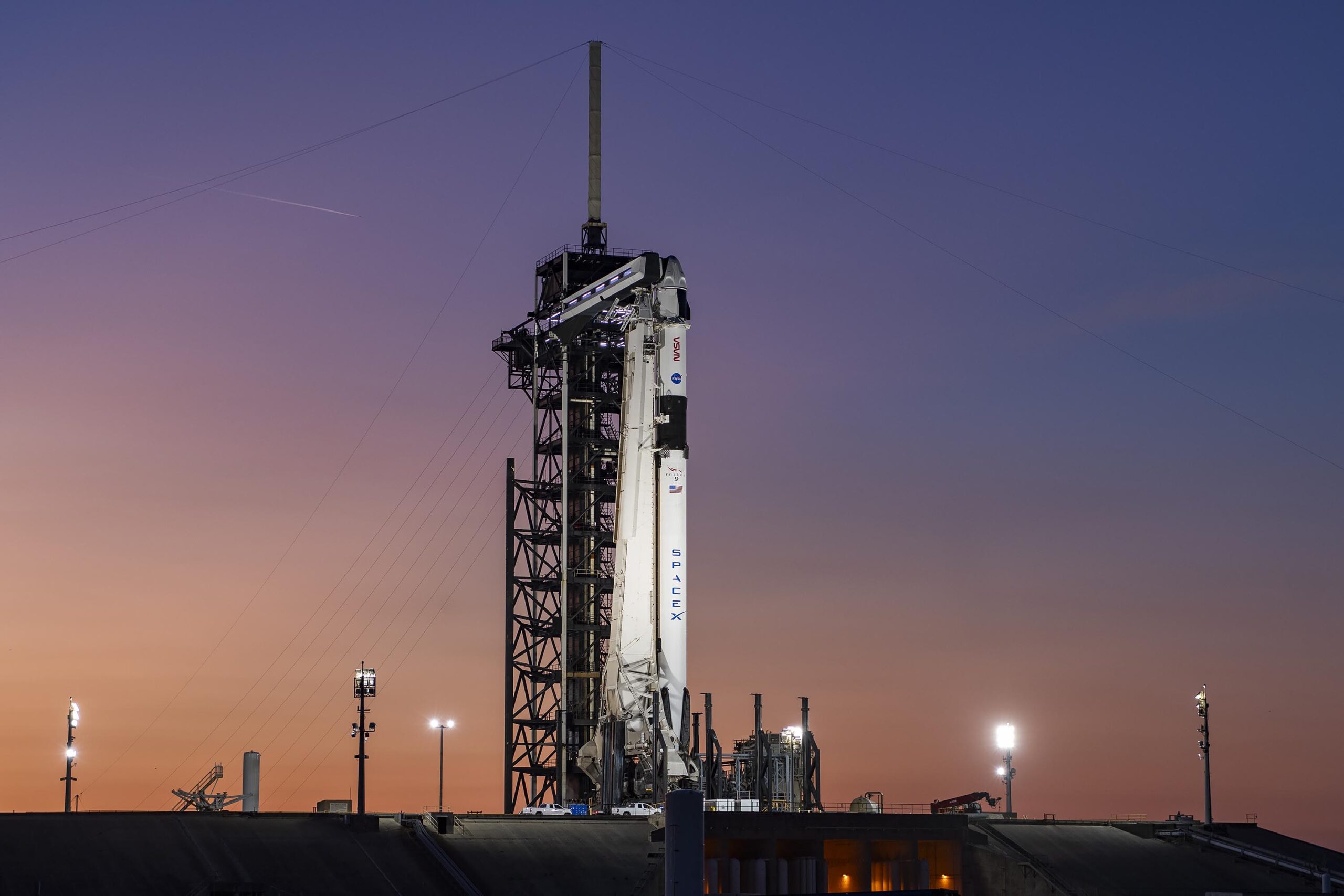 A colorful sunset serves as the backdrop for SpaceX’s Falcon 9 rocket and Dragon spacecraft on the pad at Launch Complex 39A at Kennedy Space Center in Florida ahead of the agency's SpaceX Crew-8 launch.