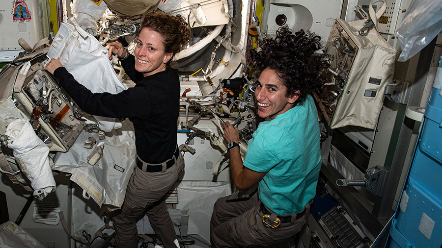 NASA astronauts (from left) Loral O'Hara and Jasmin Moghbeli work on spacesuit maintenance inside the Quest airlock.