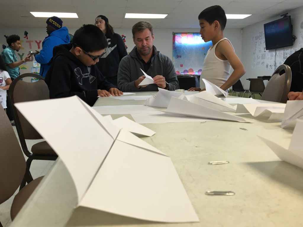 Children learning how to make paper planes