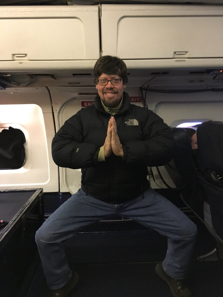  IceBridge instrument scientist, Eric Fraim, aboard the DC-8 during an hourly exercise break, practices a Barre3-inspired pose above Antarctica. Credit: NASA/Emily Schaller