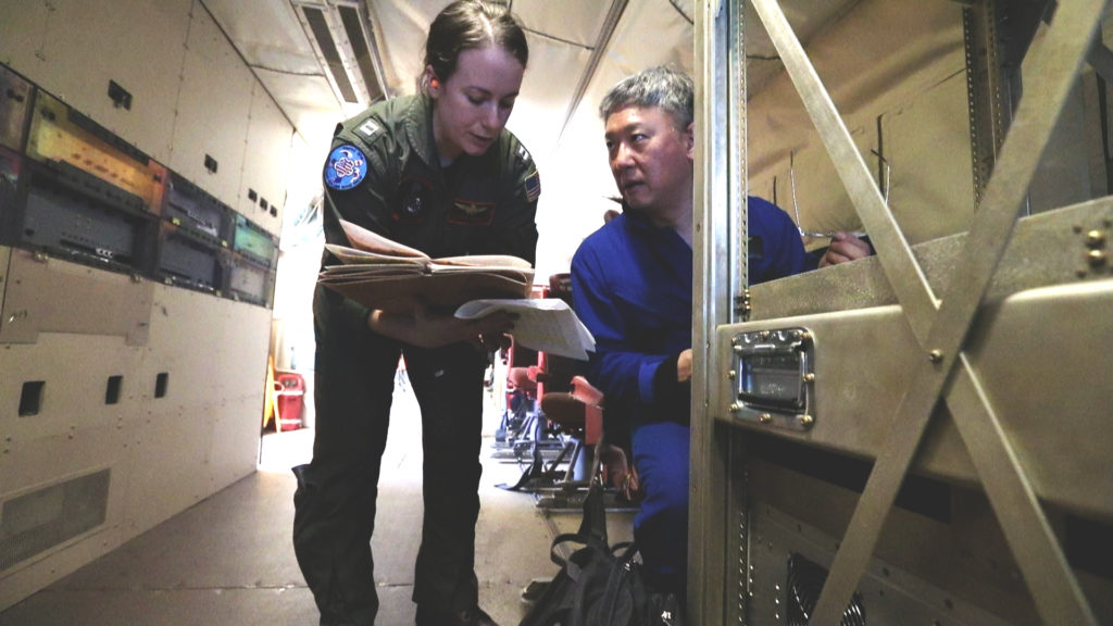 Lt. Denise Miller from the U.S. Navy speaks with Principle Investigator Edward Kim during a science flight. Credit: NASA/Joy Ng