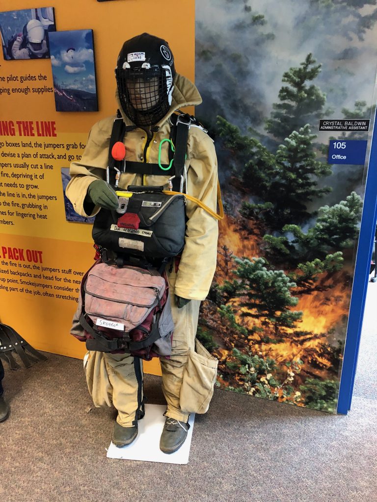 Smokejumpers wear Kevlar jump suits to avoid punctures from rocks and branches when they land in rough terrain. They also carry extra rope for getting out of trees. Credit: NASA