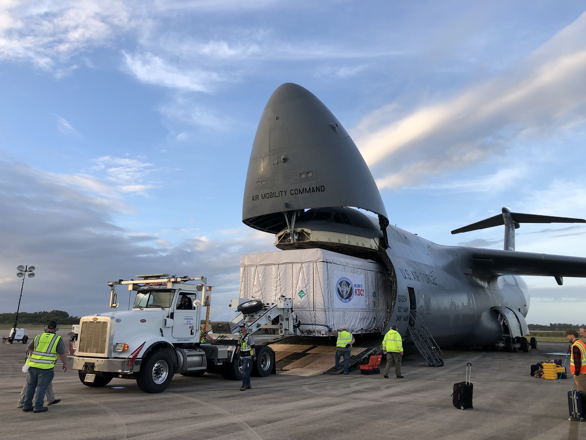 Secured inside a shipping container, the GOES-T satellite is removed from the holding area of a United States Air Force C-5 cargo plane.