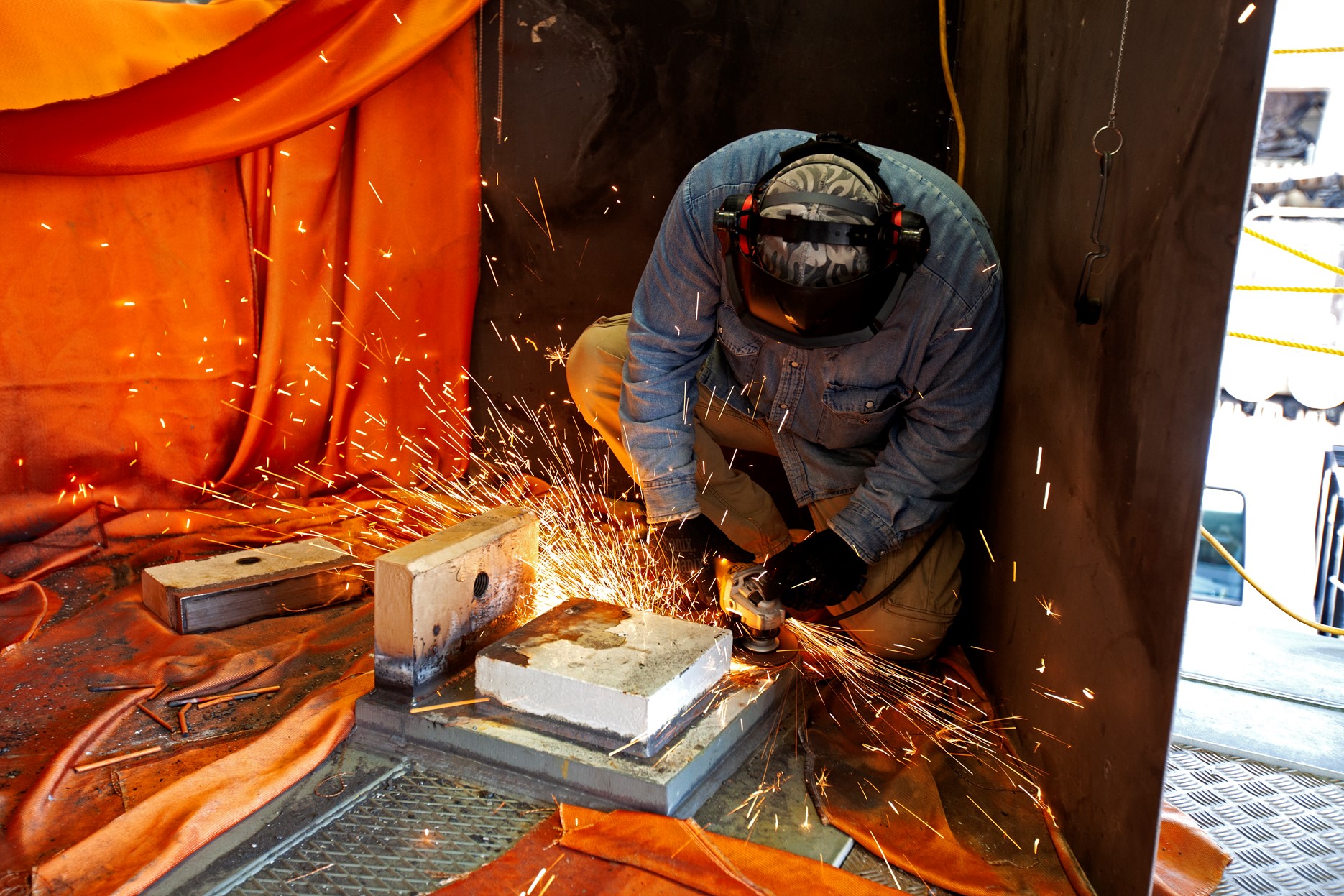 A technician performs welding on the KAMAG spacecraft transporter, inside a facility at the crawler yard at NASA’s Kennedy Space Center in Florida. Welding is being performed on the attach points that will hold the Orion transportation pallet in place (NASA/Ben Smegelsky).