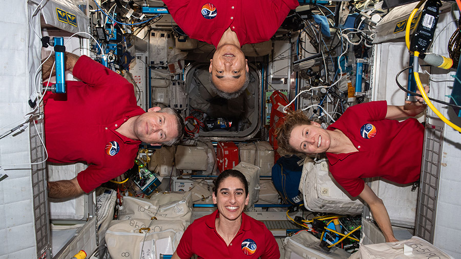 Four Expedition 70 astronauts pose for a fun portrait inside their crew quarters aboard the International Space Station's Harmony module.