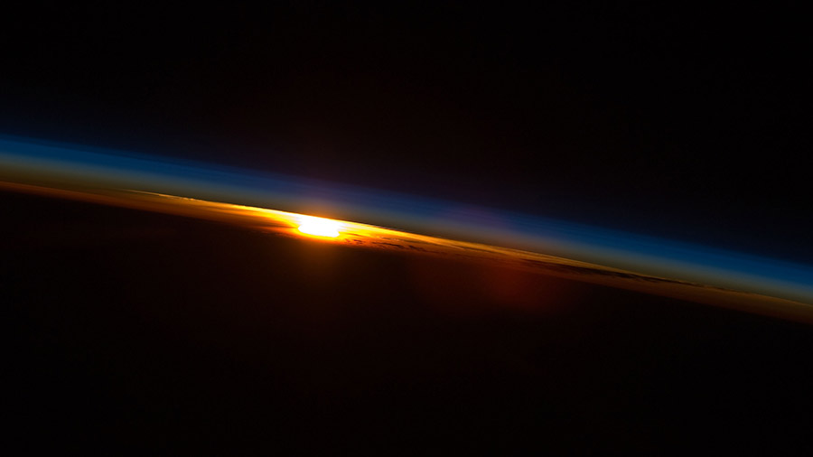 In this photograph from 2009, the sun sets below Earth's horizon illuminating the atmosphere as the space station orbited above the Indian Ocean coast of South Africa.