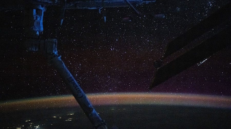 The atmospheric glow blankets Earth's nighttime horizon with a sparkling field of stars above in this photograph from the space station.