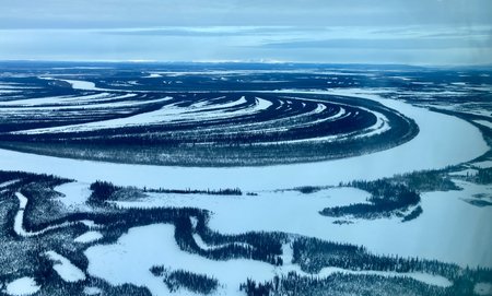 A dark blue river along white ground