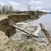 A dirt riverbank with receding edges along a river