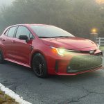 A red Toyota GR Corolla in the early morning fog