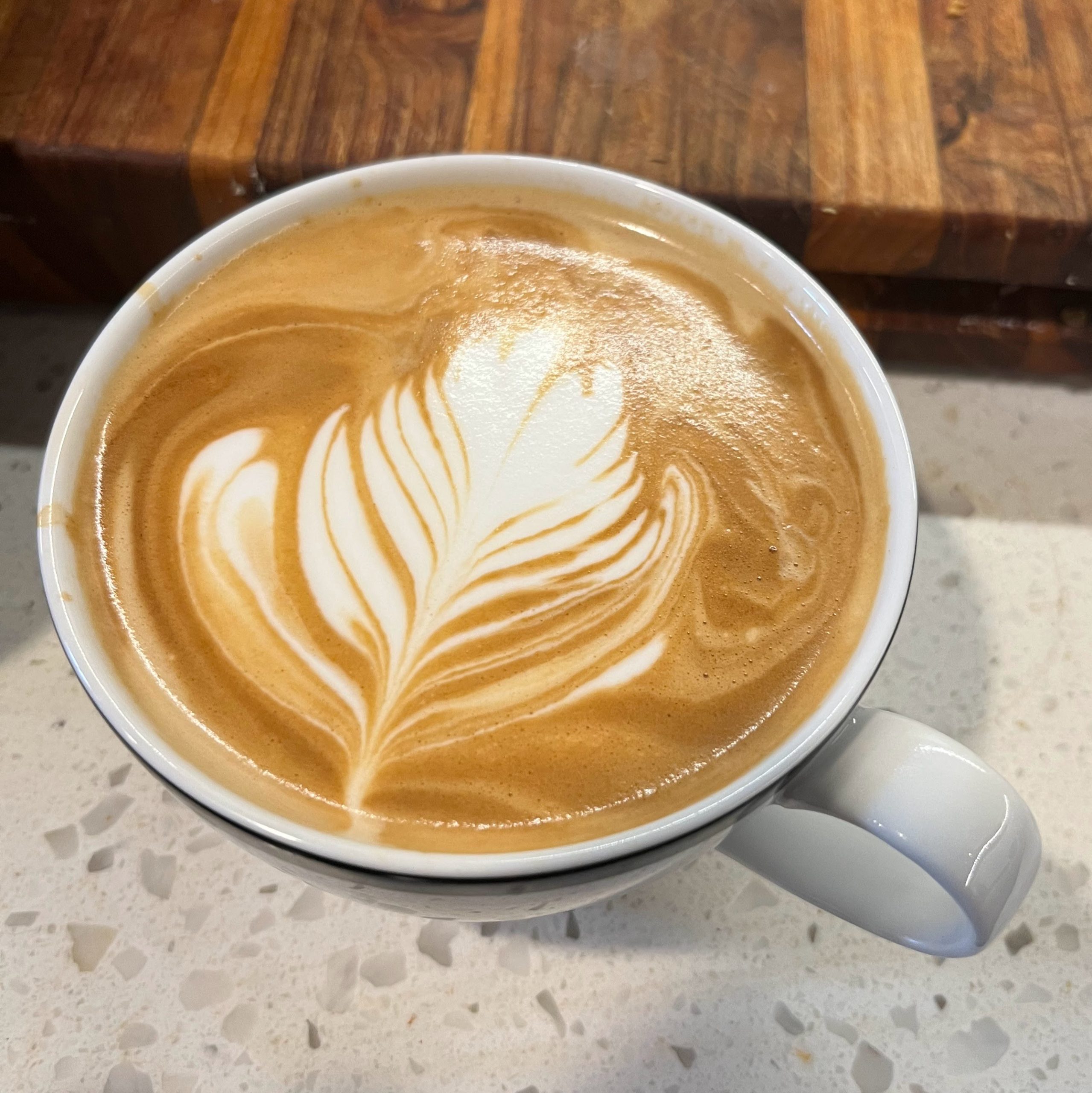 Latte in a cup with milk art in the style of a plant or flower