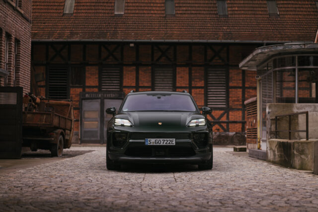 A dark green Porsche Macan 4S seen in an old industrial setting