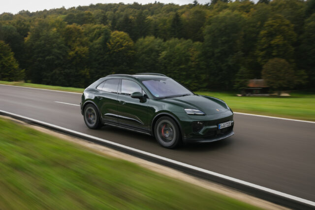 A green Porsche Macan 4S drives down a country road