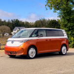 An orange and white VW ID. Buzz in a rural village in California