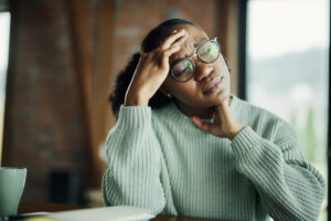 Displeased African American woman holding her head in pain.