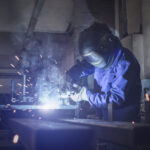 A welder at work, using tools to build new tools.