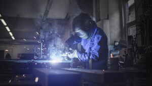 A welder at work, using tools to build new tools.