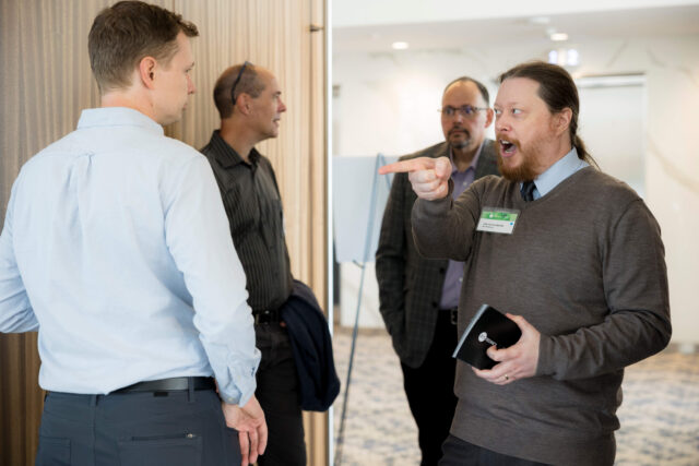 Photograph of four people talking.