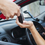 Salesman handling keys to customer